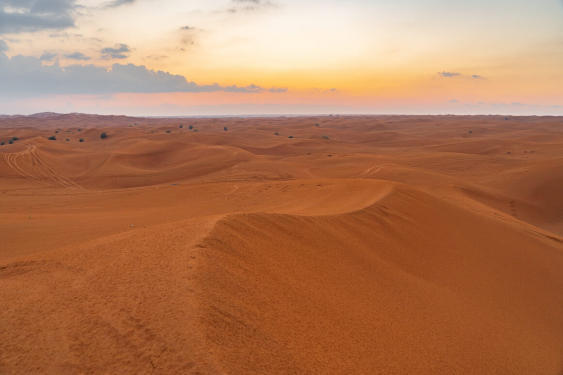 Red Desert Safari with sand dune in Dubai City, United Arab Emirates or UAE. Natural landscape background at sunset time. Famous tourist attraction. Pattern texture of sand with blue sky. 5 Ways You Can Finance Better